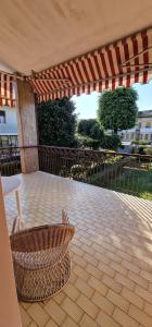 a patio with an umbrella and a chair under a table at Villa Brazil B&B in Lido di Jesolo
