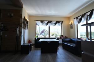 a living room with couches and a large window at Pensiunea Bergtal in Râşnov