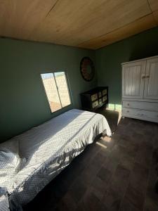 a green bedroom with a bed and a window at Bonito Estudio en una casa mobil in Mexicali