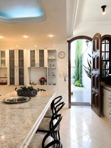 a kitchen with a counter and chairs in a room at Solar Aguilar - Casarão in Diamantina