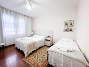 a bedroom with two beds and a rug at Solar Aguilar - Casarão in Diamantina