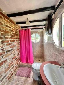 a bathroom with a pink shower curtain and a toilet at Hermoso y único chalet Duplex en Guarame, full equipo, con piscina privada y vistas a tan solo 2 minutos de playa Guacuco in Guarame +22 photos