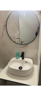 a bathroom sink with a mirror and a person taking a picture at Appartement studio au cœur de Strasbourg in Strasbourg +1 photo