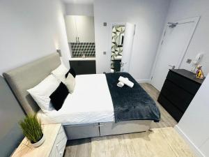 a bedroom with a bed with a black blanket on it at Wandsworth House - NO 17 - Luxury Urban Rooms in London