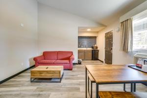 a living room with a red couch and a table at WFH-Friendly Studio Near Lighthouse Beach! in Port Huron