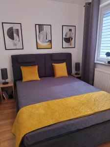 a blue bed with yellow pillows in a bedroom at Apartament dla Dwojga - Apartament typu studio in Dziwnówek