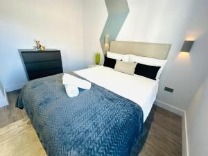 a bedroom with a large bed with a blue blanket at Wandsworth House - NO 17 - Luxury Urban Rooms in London +1 photo