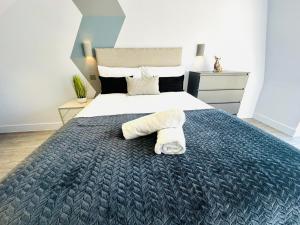 a bedroom with a large bed with a towel on it at Wandsworth House - NO 17 - Luxury Urban Rooms in London