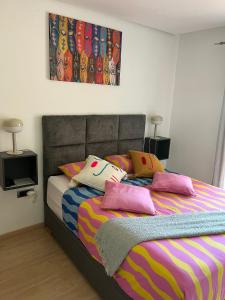 a bedroom with a bed with colorful blankets and pillows at Marrakech Golf City Prestigia 4 minutes du centre in Marrakech