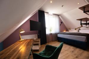 a bedroom with a bed and a desk and a table at Boutique Apartments by Roy Oberhausen in Oberhausen