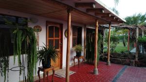 a house with potted plants on a patio at Rural retreat pool, 6ppl - 5min beach - SuperHost in Mala