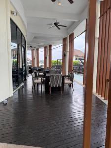 a dining room with a table and chairs and windows at Avani Sepang Goldcoast Resort in Tanjong Sepat