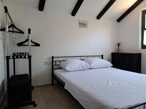 a bedroom with a bed with white sheets and white pillows at House Murtelica in Tkon