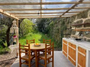 eine Außenküche mit einem Holztisch und Stühlen in der Unterkunft Ananda Glamping natural escape in Palazzolo Acreide