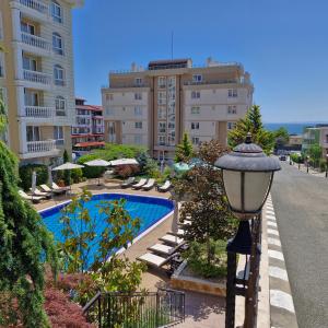 un lampadaire à côté d'une piscine avec des bâtiments dans l'établissement Villa Sardinia Sveti Vlas Studio, à Sveti Vlas