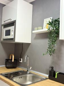 una cocina con fregadero y microondas en Ámplio piso en el corazón de Torremolinos, en Torremolinos