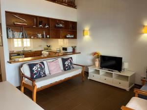 ein Wohnzimmer mit Sofa und Fernseher in der Unterkunft ES FAR AZUL by SOM Menorca in Fornells