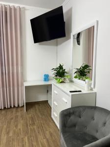 a living room with a couch and a tv on the wall at Casa Lady in Pontremoli