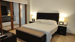 クルス・デ・ウアナカストレにあるLovely apartment in Cruz de Huanacaxtleの大きなベッドと2つのランプがある寝室 +30枚の写真