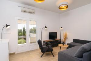 a living room with a couch and a desk with a television at Paradise found in Komiža