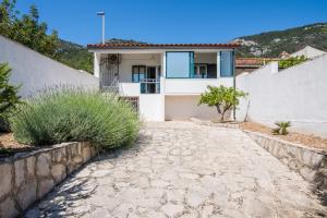 a house with a stone driveway in front of it at Paradise found in Komiža