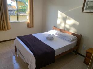a bedroom with a bed with two towels on it at Casa 6 Mares de Búzios - 5 minutos a pé da Rua das Pedras in Búzios +21 photos