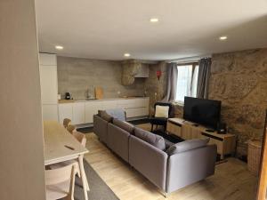 a living room with a couch and a television at Casa da Palheira in Sabugueiro