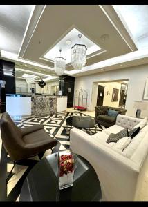 a living room with couches and chairs and a television at Amman studio Damac Tower in Amman