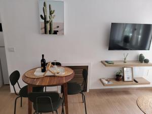 a dining room with a table and chairs and a tv at Oasis Las Eras, Tenerife in Las Eras