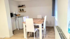 a kitchen with a wooden table and white chairs at Modern apartment im Herzen des Schwarzwald v-s in Villingen-Schwenningen