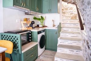 a kitchen with green cabinets and a washer and dryer at Stefania's Mountain Tale in Makrinitsa