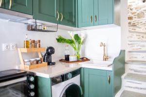 a kitchen with green cabinets and a washing machine at Stefania's Mountain Tale in Makrinitsa