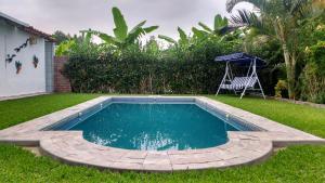 a swimming pool in a yard with a chair next to it at Snug Bungalow - 4 people - Pool - SuperHost in Mala