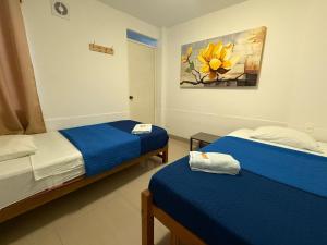 a room with two beds and a painting on the wall at SG Paracas Hostel in Paracas