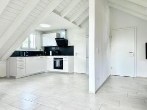 una cucina con armadietti bianchi e pavimento bianco di Loft apartment in a central location a Winterthur Altre 20 foto