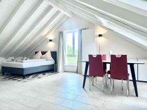 una camera da letto con tavolo, sedie e un letto di Loft apartment in a central location a Winterthur