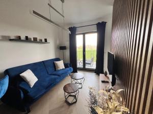 salon z niebieską kanapą i oknem w obiekcie Apartament Pierwsza Dzielnica w mieście Katowice