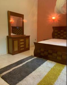 a bedroom with a bed and a mirror and a rug at Chez awa in Saint-Louis