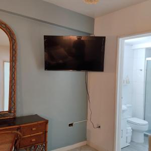a bathroom with a toilet and a television on the wall at Beach apartment in La Mar Suites, Tucacas Venezuela in Tucacas