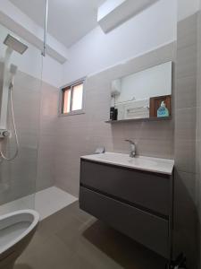 Un baño con lavabo, inodoro y espejo. en Charmant F1 avec Balcon - Wi-Fi & TV Connectée à Dakar, en Dakar 41 fotos más