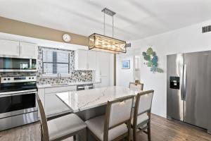 a kitchen with a dining table and a stainless steel refrigerator at Anglers Cove Unit J205 in Marco Island