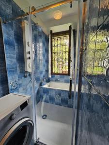 a blue tiled bathroom with a shower and a washing machine at VILLA LAGO GROUND FLOOR- Pet friendly stay-private garden-parking-Lake view - Bike friendly holiday house in Colico +60 photos
