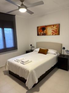 a bedroom with a large bed with a ceiling fan at Laguna del Flamenco in Torrevieja