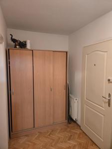 a room with a large wooden cabinet and a door at Apartman u Nisu in Niš