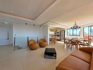 un salon avec une table et une salle à manger dans l'établissement Cobertura Centro de Foz - Duplex com piscina, à Foz do Iguaçu