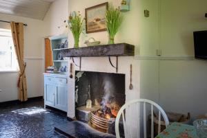 a fireplace in a living room with a fire place at McGuire's Red Door Cottages in Drumshanbo