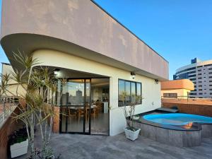 une maison avec une piscine devant dans l'établissement Cobertura Centro de Foz - Duplex com piscina, à Foz do Iguaçu