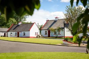 two white and red houses on the side of a road at McGuire's Red Door Cottages in Drumshanbo