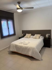a bedroom with a large bed with a ceiling fan at Laguna del Flamenco in Torrevieja
