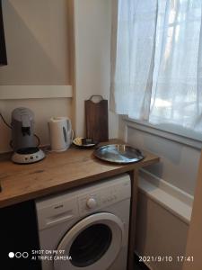 a kitchen with a washing machine and a counter at Du Guesclin Appart in Saint-Brieuc